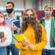 Youth Funder relationships: 4 teens wearing masks holding books and a basketball in OST gym program