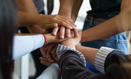 mental health, juvenile justice, Restorative justice: Closeup of hands of several people of multiple ethnicity stacked on each other