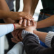 mental health, juvenile justice, Restorative justice: Closeup of hands of several people of multiple ethnicity stacked on each other