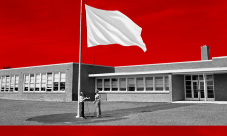 Civic curriculum debate: Two children face each other at very tall flagpole raising an all-white flag up the pole that is on a lawn in front of a one-story brick building with multiple large windows. Red sky above building.