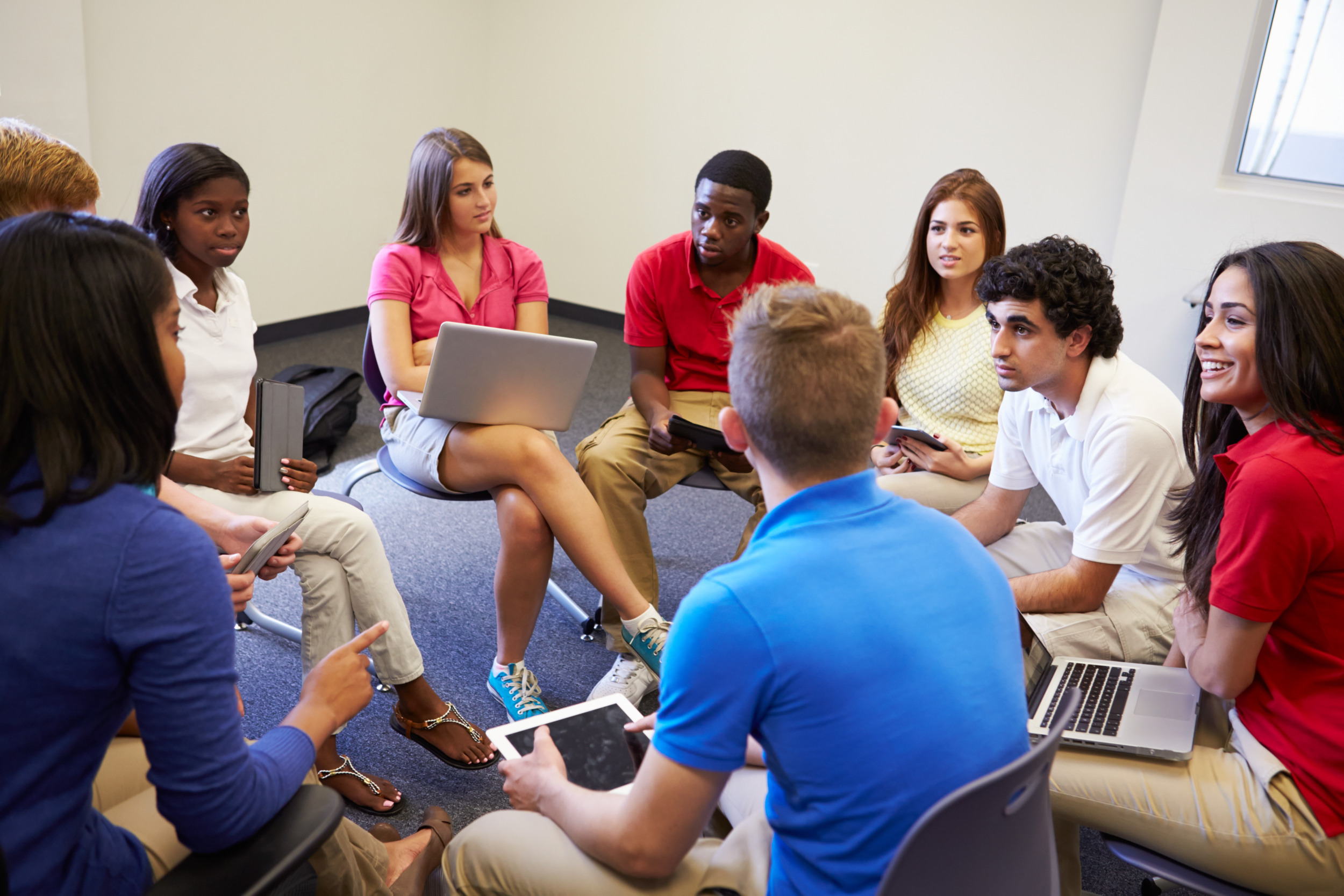 Restorative justice: Several high school students sit in a circle of chairs having a discussion