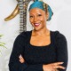 Q&A_Monique Couvson on why philanthropy should cede power to girls of color: black woman with colorful head scarf and dark shirt smiling with arms folded