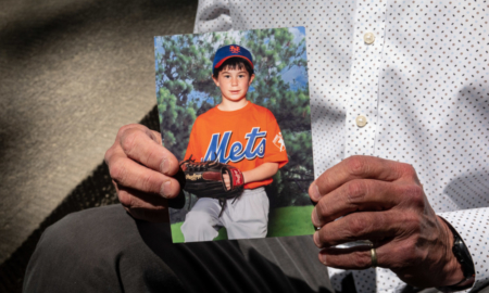 ghost gun rule: hands holding a picture of child in baseball uniform