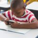 beyond suspensions report; young disable black student working on tablet at desk