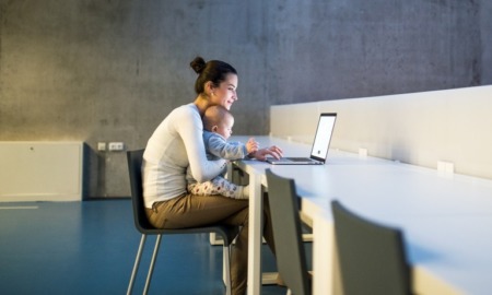 roadmap for change to support parenting teens and students: young mother and baby at laptop in a large room smiling