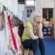 teacher mental health support: young woman teacher sits on bench in school hallway looking out window in thought