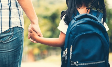 school safety grants: parent holding hand of child going to school