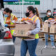 NP Toolbox Donor communications: Three women in masks wearing work clothes load carboard boxes filled with food donations into vehicles