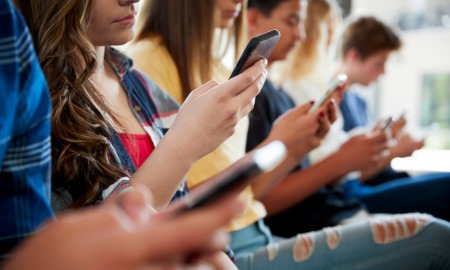 Teens, social media and technology 2023 report: line of teens looking at their phones