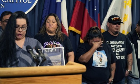 Uvalde families plead for languishing Texas gun bills: group of people in black shirts stand next to someone speaking at podium