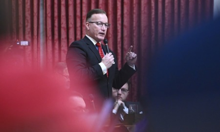 West Virginia passes campus carry bill: white man in suit and glasses speaks into microphone