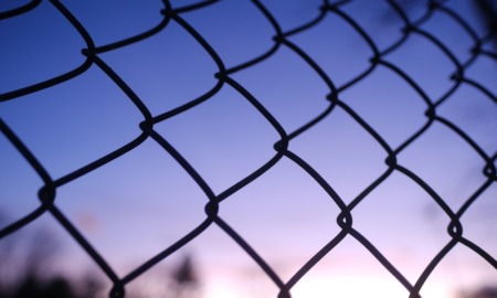 institutionalized children run: chain link fence with sunset