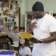 Youth program founder hurt in shooting 'has biggest heart': black man in black beanie reading happily to a classroom of students