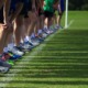 youth running grants: shoes and legs of youths lined up at beginning of race