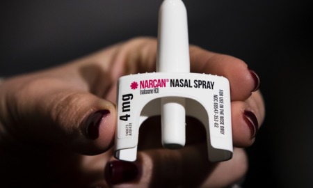 youth overdose renews pleas for Narcan in schools: hand holding Narcan nasal spray on black background