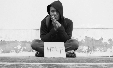 homeless and street youth services grants; homeless teen sitting on ground with help sign