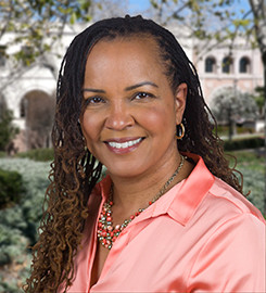 Neurodivergent student empowerment in college: Headshot black woman with long brown hair in coral short