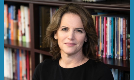 Nicola Diamond newsmaker headshot, brunette woman smiling at camera in front of bookshelves