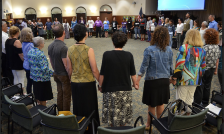 Florida: Very large circle of people hold hands indoors