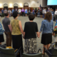 Florida: Very large circle of people hold hands indoors