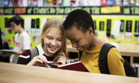 charter school effects on school segregation report; black and white students reading together in school