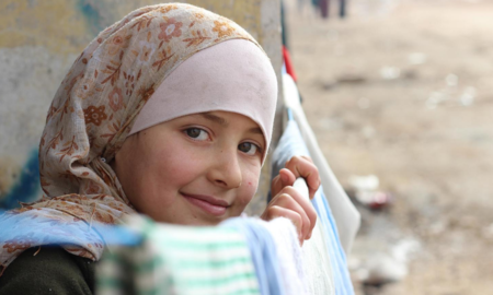 Lost At Home: The Risks and Challenges for Internally Displaced Children report cover; young girl in hijab smiling at camera