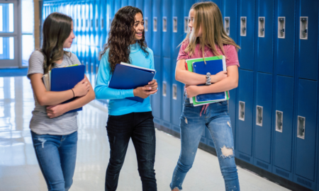 school segregation report; young female students walking down school hallway